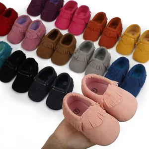 Detailansicht von weichen Baby-Mädchen-Mokassins mit Fransen in verschiedenen Farben.