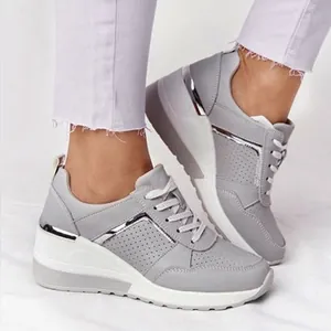 Seitenansicht-Detail grauer Plateau-Sneaker mit silbernem Metallbesatz und Schnürsenkeln