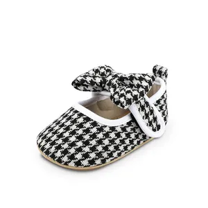 Infant girl walking shoe with black and white houndstooth pattern and bow detail