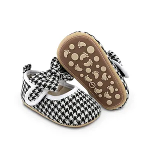 Close-up of houndstooth baby girl walking shoes with decorative bow and non-slip rubber sole