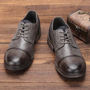 Detail view of men's vintage burnished leather shoes on a rustic wooden background