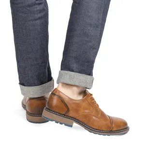 Close-up of men's burnished brown leather oxford shoes worn with denim jeans.
