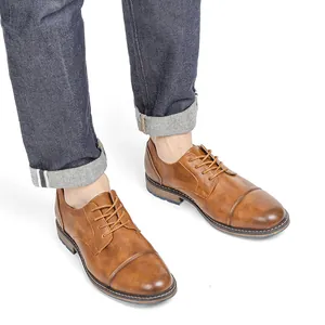 Classic brown rubbed leather cap-toe dress shoes for men worn with casual blue jeans