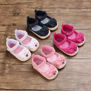 Close-up van schattige babysandalen met zachte zool, stippen en strikken in diverse kleuren