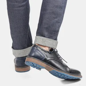 Detail view of men's burnished leather business casual shoes with blue non-slip sole