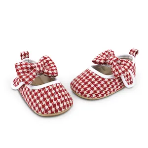 Detailed view of red houndstooth baby girl walking shoes with a charming bow accent