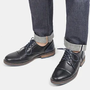 Detail view of men's black leather business casual shoes with blue stitching