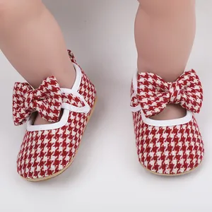 Close-up of red houndstooth baby walking shoes with bow decoration