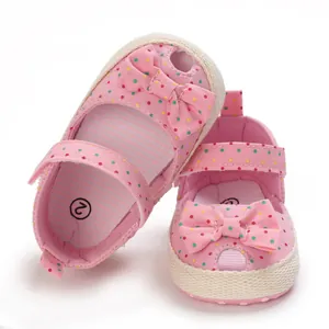 Detail van roze gestipte baby loopzandalen met zachte zolen en een schattige strik