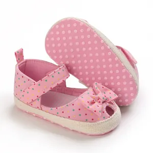 Detail van roze babysandalen met stippen, zachte zool en strik
