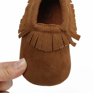Detailaufnahme von weichen braunen Wildleder-Babyschuhen mit stilvollen Fransen