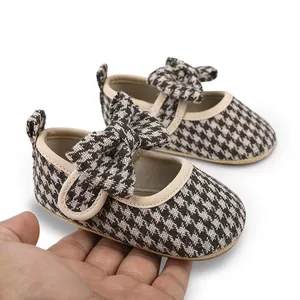 Close-up view of baby girl houndstooth Mary Jane walking shoes with cute bow detail
