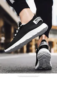 Primo piano di sneaker da uomo in rete nera traspirante con suola in EVA bianca resistente