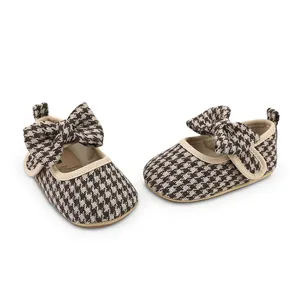 Detailed shot of houndstooth baby walking shoes with decorative bow and non-slip rubber sole