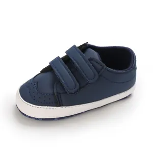 Detailed view of navy blue soft-sole infant walking shoes with double velcro straps