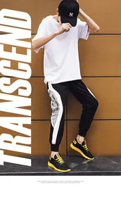 Vista laterale di scarpe sportive da uomo nere e gialle con pantaloni jogger e t-shirt