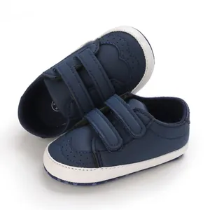 Detailed view of navy blue baby pre-walker shoes with white soles and velcro straps