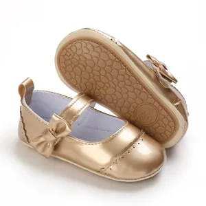 Close-up view of gold metallic baby princess walking shoes featuring a bow and soft sole