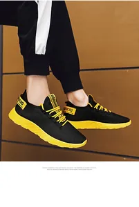 Vista dettagliata di sneaker in mesh nero traspirante con suola in EVA giallo vivace.