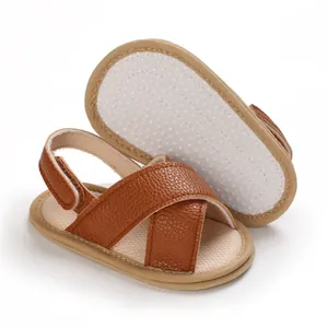 Primer plano de sandalias para bebé con tiras cruzadas y suela suave