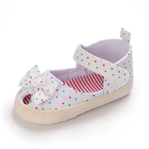 Gedetailleerde weergave van baby-wandelsandalen met gekleurde stippen en een strik