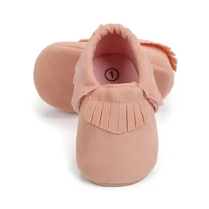 Nahaufnahme rosa Wildleder Babyschuhe mit Fransen und Größenmarkierung 1 auf der Innensohle.