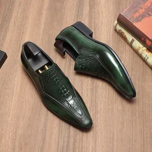 Detalle de mocasines de cuero verde con punta fina, textura de cocodrilo y acabado brillante.