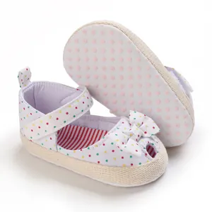 Detail van baby sandalen met zachte zool, gekleurde stippen en een schattige strik