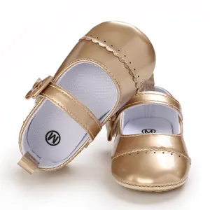 Detailed macro view of shiny metallic gold baby Mary Jane shoes with bow decoration