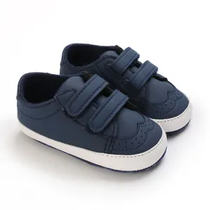 Close-up of navy blue baby walking shoes with white soles and velcro straps