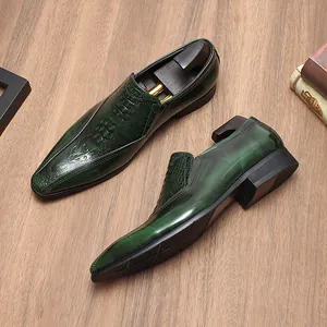 Primer plano de mocasines de cuero verde oscuro con estampado de cocodrilo en madera