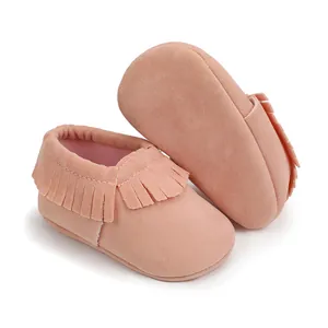 Detaillierte Ansicht weicher rosa Wildleder-Babyschuhe mit stilvollem Fransendesign