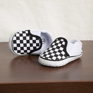 Vista dettagliata delle scarpe da bambino con motivo a scacchi bianchi e neri e suola morbida
