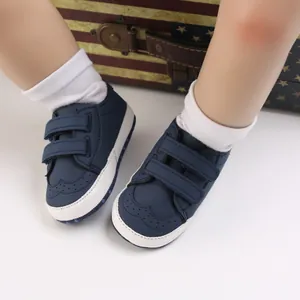 Macro view of navy blue baby toddler shoes with soft soles and double hook-and-loop straps