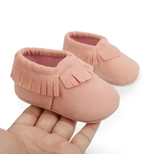 Weiche rosa Wildleder Babyschuhe mit Fransen Detail als Größenreferenz gehalten