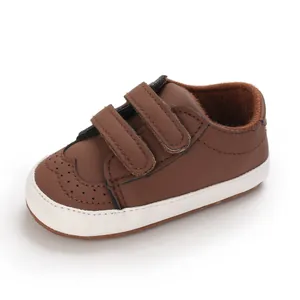 Detail view of brown baby walking shoe featuring double velcro straps and soft white sole
