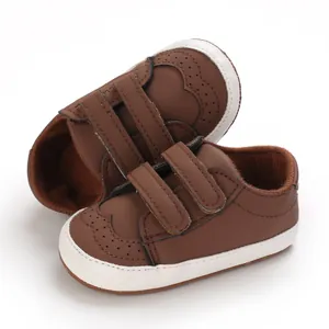 Brown soft sole baby walker shoes featuring double velcro straps and brogue perforation details