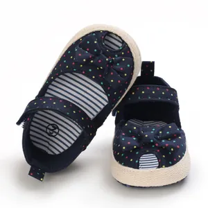 Detailopname van marineblauwe babysandalen met stippen, strik en gestreepte voering