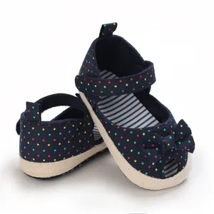 Detailopname van marineblauwe baby sandalen met stippen, een strik en zachte zool