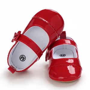 Close-up detail of red patent leather baby princess walking shoes with bow