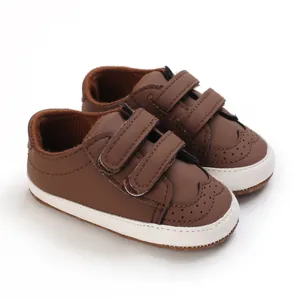 Detailed close-up of brown infant walking shoes with soft soles and velcro straps