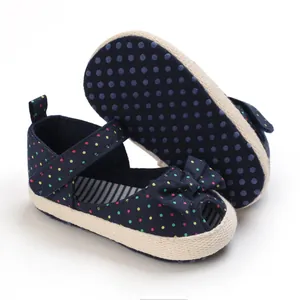 Gedetailleerde weergave van marineblauwe babystippelschoenen met strik en zachte zool