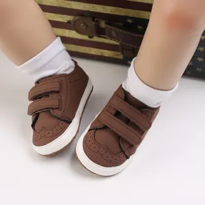 Close-up of brown baby walking shoes featuring dual velcro straps and soft soles