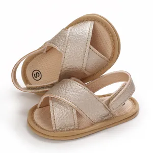 Detalle de las sandalias para bebé en color oro champán con suela blanda y velcro.