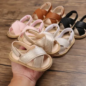 Detalle que muestra varios colores de sandalias para bebés sobre una superficie de madera