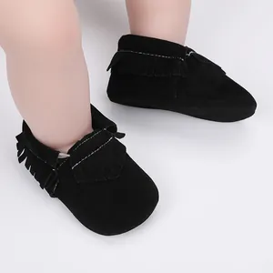 Detailansicht weicher schwarzer Wildleder-Babyschuhe mit stilvollen Fransenakzenten.