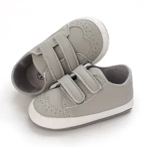 Detail view of grey baby walking shoes featuring soft soles and dual hook-and-loop straps