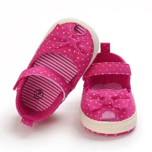 Detailopname van roze babysandalen met stippen, strik en zachte zool detail weergave