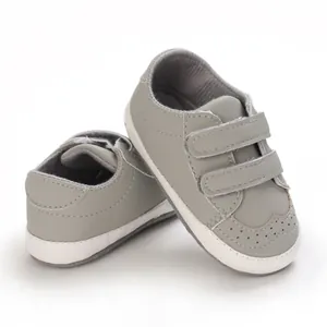 Detailed shot of grey soft-sole baby walking shoes with dual velcro straps for 0-1 year olds.