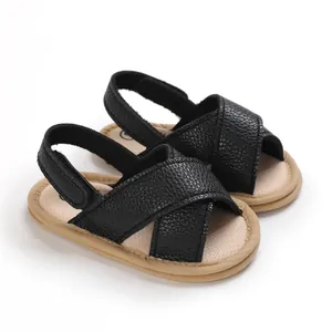 Vista detallada de sandalias negras para bebé con suelas blandas y diseño cruzado